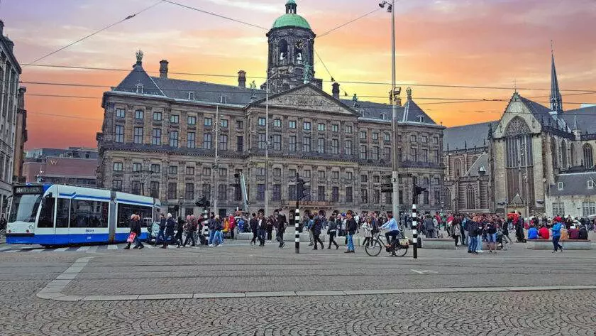 Fă o plimbare cu bicicleta prin Piața Dam din Amsterdam, Olanda